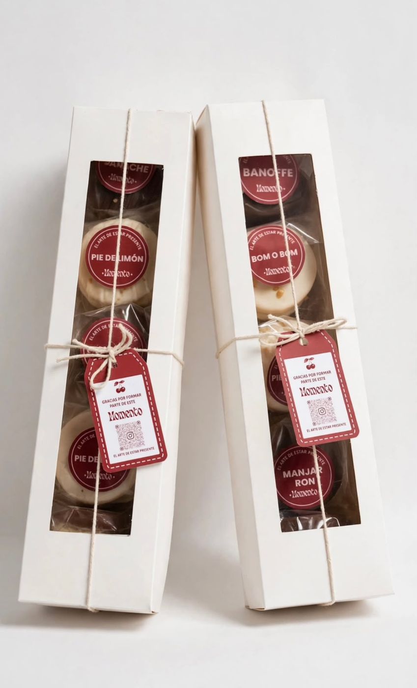 Dos cajas largas de Momento con visor, alfajores rotulados por sabor, cordel y la etiqueta burdeo.